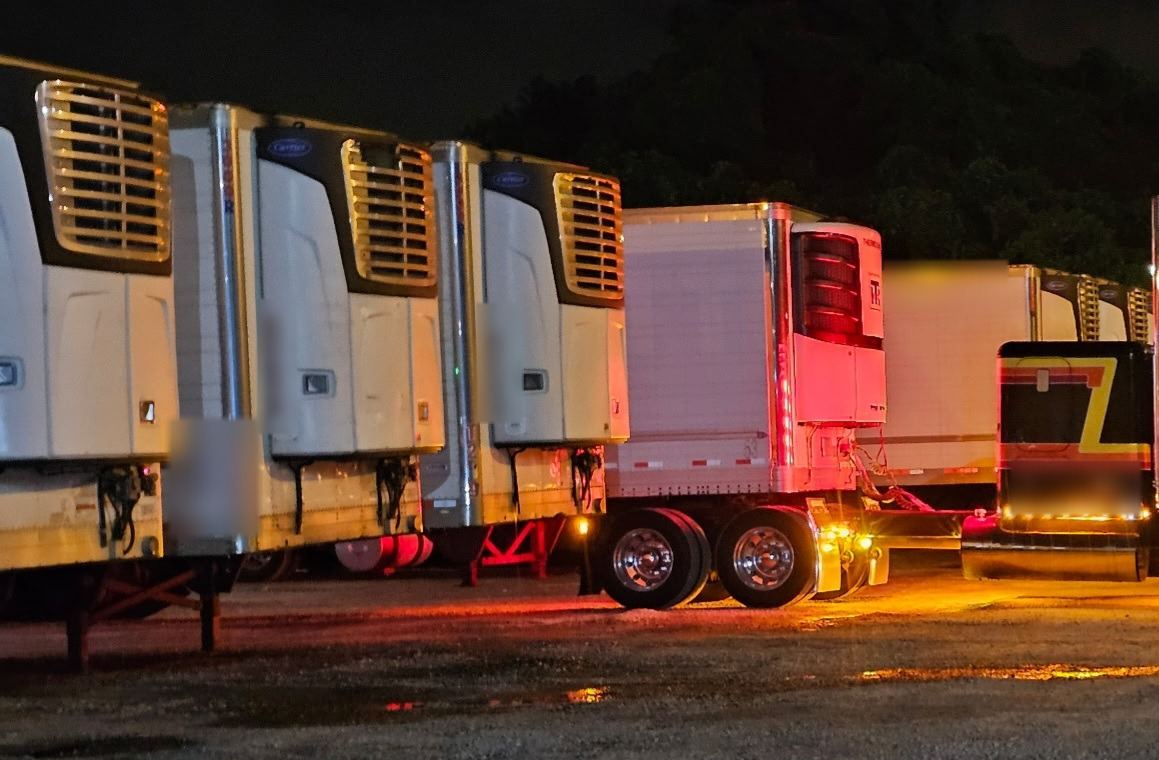 Reefer trailers lined up in a yard at night
